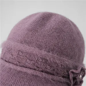 Close-up of soft lilac knit winter hat for women with fluffy texture and floral detail
