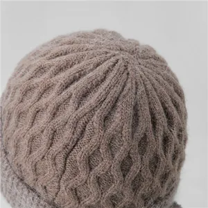 Primer plano de gorro de punto marrón con trenzado grueso y textura de mohair suave