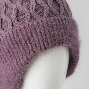 Close-up of deep purple knit hat showing intricate cable stitch and soft fuzzy texture
