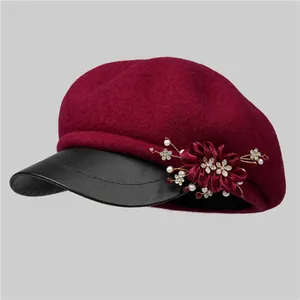 Detailed side view of burgundy wool newsboy cap with elegant floral pearl decoration