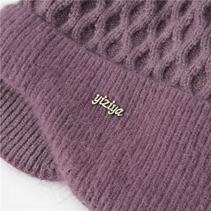 Detailed macro view of purple knitted texture and silver metal brand logo on winter hat