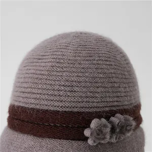 Detalle de gorro de punto de invierno con decoración floral y textura de piel para mujer