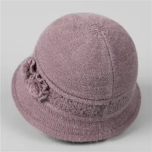 Close-up of a purple knitted bucket hat with exquisite flower and pom-pom detailing