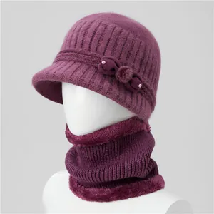 Detail of dark purple knitted winter hat and faux fur neck gaiter with bow and pearls