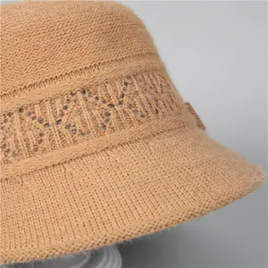 Detailed macro view of camel knit hat texture with floral patterns and leather tag