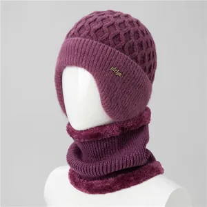 Close-up of deep purple knitted hat with fleece lining and faux fur trim for elderly women