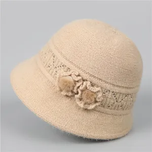 Detail of knit bucket hat featuring decorative 3D flowers and soft fur balls for elderly women
