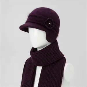 Detail of deep purple knit hat featuring a floral ornament and matching warm ribbed scarf