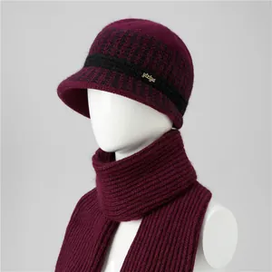 Detalle de gorro estilo bucket de pelo de conejo burdeos y bufanda con ribete a cuadros