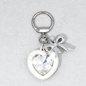 Close-up of heart-shaped crystal keychain with silver bow and metal spring clasp