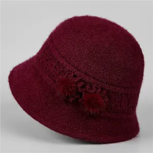Detail of wine red knit bucket hat for elderly women with decorative pom-poms and textures