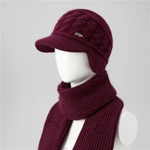 Detailed close-up of wine red knit hat and scarf set with cable pattern and visor