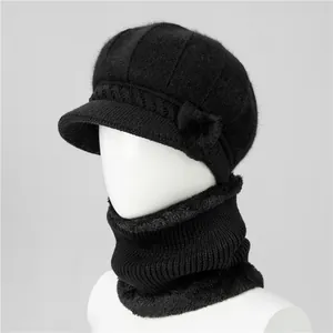Dettaglio del set cappello in maglia nera e scaldacollo con fodera in ecopelliccia e pompon