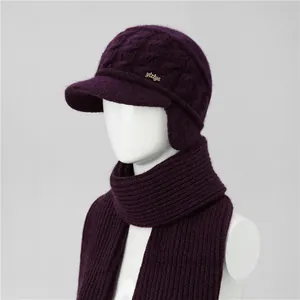 Detail view of dark purple winter knitted ear protection hat with gold logo and matching scarf