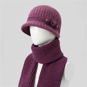 Detail of purple knit winter hat and scarf set with pearls, bow, and soft fur pom-pom decor