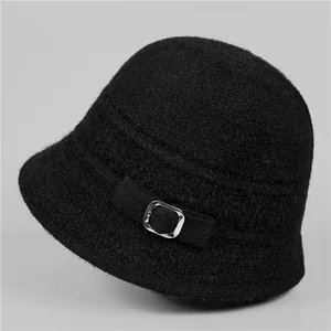 Close-up of black knit winter bucket hat featuring furry texture and silver metal buckle
