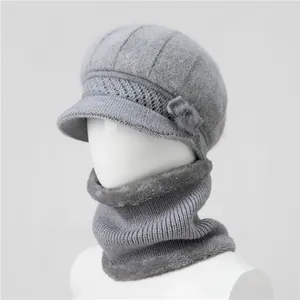 Dettaglio del cappello in maglia grigia con accento floreale e fodera in pile per donna