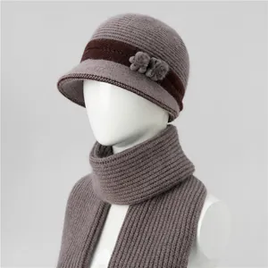 Detalle de gorro de punto morado con adorno floral y conjunto de bufanda de invierno