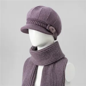 Dettaglio del set berretto e sciarpa in maglia viola con fiocco e pompon