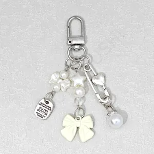 Detailed macro view of handcrafted silver-tone key charm with pearls and bow