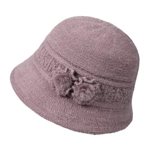 Women's warm winter knitted bucket hat with decorative flowers and pompoms in dusty rose