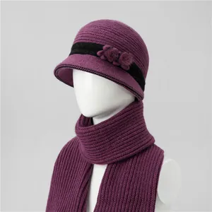 Detalle de conjunto de gorro y bufanda de punto violeta con flor para mujeres mayores
