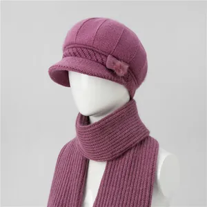 Dettaglio set cappello e sciarpa in maglia viola scuro con fiocco e pompon di peluche