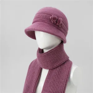Detalle de gorro de punto morado con flores y bufanda de invierno a juego