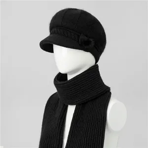 Dettaglio del cappello in maglia nera con visiera e sciarpa abbinata su un manichino