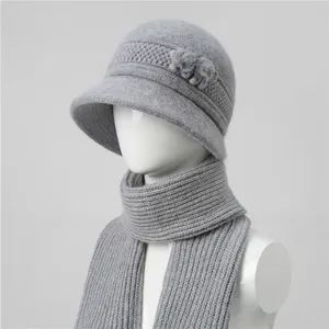 Detalle de textura de punto del conjunto gris de gorro y bufanda con pompones