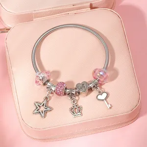 Elegant beaded spring bracelet with pink glass beads and silver charms on pink box