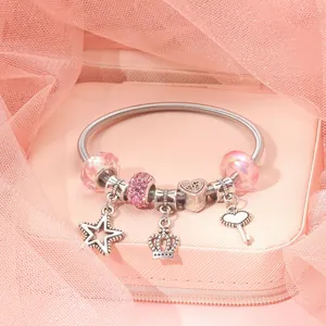 Detail of silver beaded bracelet with pink glass charms and heart crown star pendants