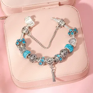 Detail of silver snake chain bracelet with blue crystals and heart love charm