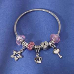 Silver beaded bracelet featuring pink glass beads, heart, star and crown charms