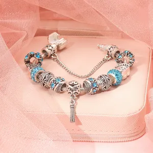 Close-up of DIY silver-plated snake chain bracelet with blue crystal beads and tassels