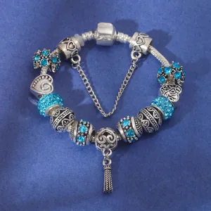 Detail of silver snake chain bracelet with blue rhinestones and LOVE heart charm