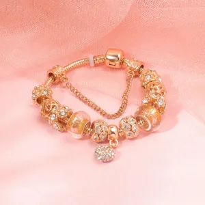 Detail of rose gold snake chain bracelet with sparkling heart charm and beads