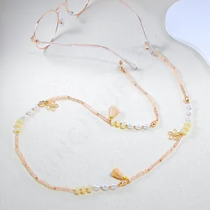 Detail of beaded eyewear chain with pastel beads, golden flowers and soft tassels