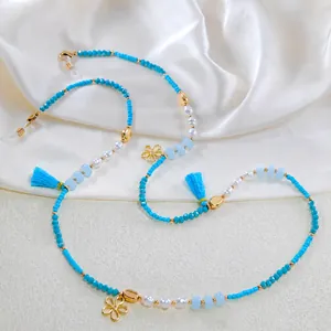 Detail einer Boho-Brillenkette mit himmelblauen Perlen, Quasten und goldenen Blumen