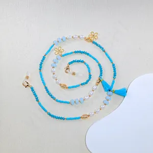 Detail of bohemian eyewear chain with turquoise beads, white pearls and blue tassels