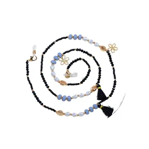 Beaded eyewear chain with blue pearls, gold flowers, and black tassels on white background