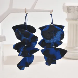 Detail of handmade leopard print fabric petal earrings with dark blue beads on a display