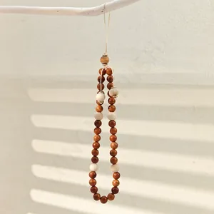 Minimalist wooden beaded phone strap featuring natural light and dark brown round beads