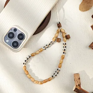Detail of bohemian phone strap with natural wood beads and striped patterns