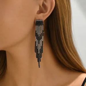 Close-up of long black fringe tassel earrings with rhinestones on fashion model