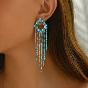 Close-up of long tassel earrings with light blue rhinestones on a female model
