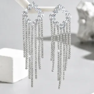 Close-up of elegant long tassel earrings with marquise-cut zircon stones and silver chains