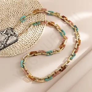 Detail of colorful acrylic phone chain with gold metal links and snake print accessory