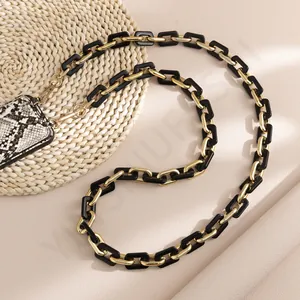 Detail of acrylic link phone strap with gold metal rings and snakeskin texture