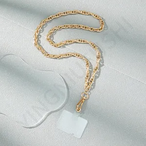 Detail of a golden metal chain phone strap with lobster clasp and transparent PVC card